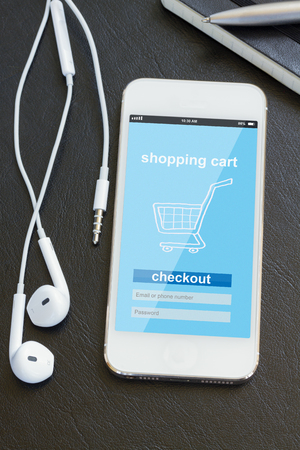 mobile shopping - modern smart phone with shoppnig cart on screenの写真素材