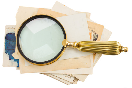 pile of old postcards with loupe  isolated on white の写真素材