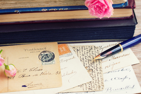 quill pen and antique letters on table with books