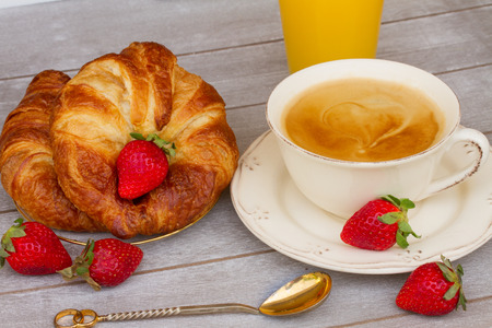 breakfast with croissants,  coffee, strawberries and orange  juiceの写真素材