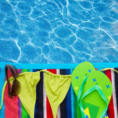 sandals ans swimming suit on towel border by poolsideの写真素材