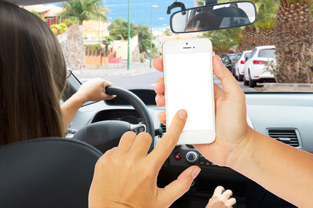hands holding a touch phone with empty  screen on a background woman driving a car
