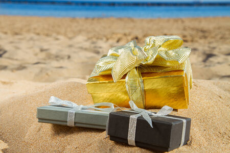 pile of christmas gifts on beach  with golden sandの写真素材