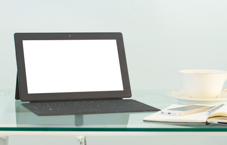 Modern working place with tablet  and coffee mug on glass  table