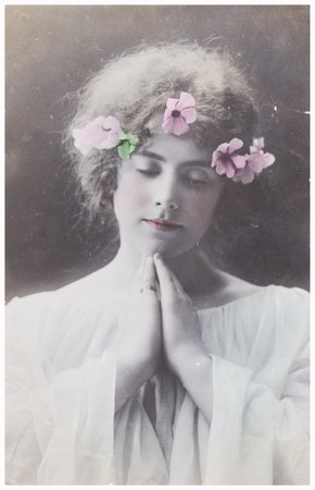 POLAND, WARSAW - CIRCA 1900s: old photo portrait of young woman praying in flower wreath....