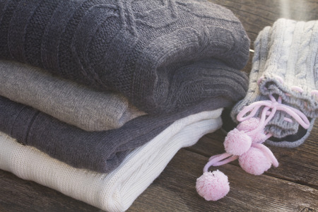 stack of warm folded woolen clothes on wooden table