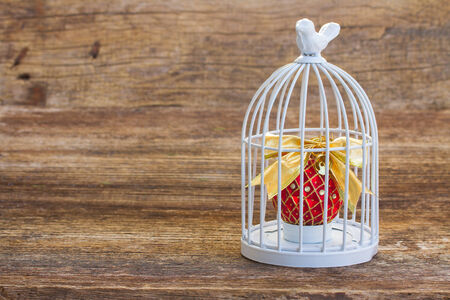 cage with christmas ball on wooden background with copy spaceの写真素材