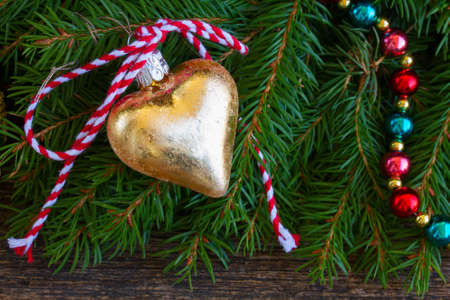 golden christmas heart  on evergreen tree backgroundの写真素材