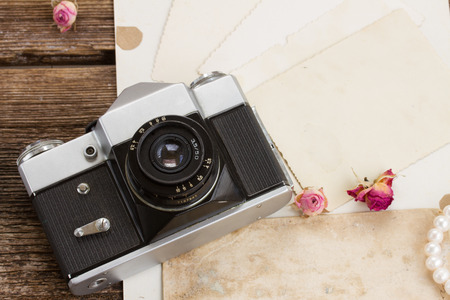 vintage camera with pile of old photosの写真素材