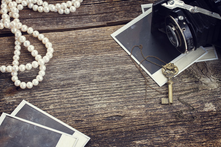 frame of vintage  photo camera on pile of old instant photos on wooden backgroundの写真素材
