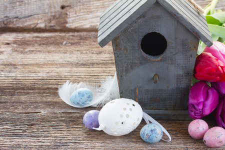 easter  eggs  with birdcage and  flowers on tableの写真素材