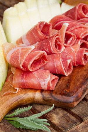 slices  of spanish cured pork ham jamon with melon close upの写真素材