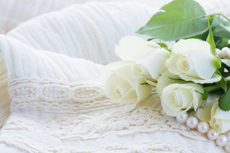white fresh  roses with  pearls on white lace backgroundの写真素材