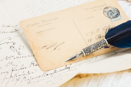 old postcard with feather penの写真素材