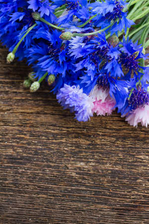 Blue cornflowers on wooden table with copy spaceの写真素材