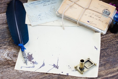 pile of  antique letters with ink stains  and blue  feather penの写真素材
