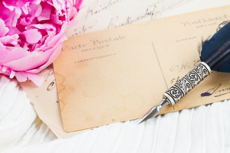 Pink peony with antique  blank letter  with copy space and feather pen on white lace backgroundの写真素材