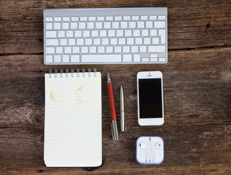 Top view office workplace - keyboard with phone and empty  notebook on woodの写真素材