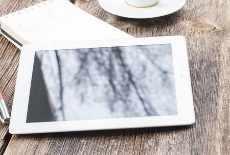 Coffee break with white  tablet on wooden tableの写真素材