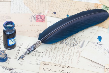 blue  feather pen and inkwell on  old papers and  letter backgroundの写真素材