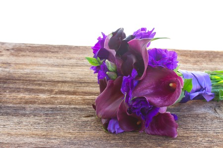 Bouquet of fresh calla lilly and eustoma flowers  on wooden table isolated on white backgroundの写真素材