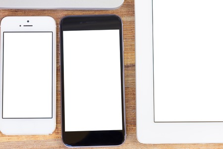 Phones and tablet  with blanck screen on wooden table
