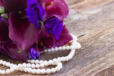 violet  calla lilly and eustoma flowers with pearls  on wooden tableの写真素材