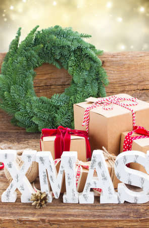 Xmas letters and handmade gift boxes with evergreen  fir tree wreath in backgroundの写真素材