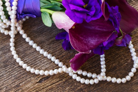 fresh calla lilly and eustoma flowers close up on wooden tableの写真素材