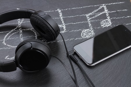Music notes with treble clef, smartphone  and headphones
