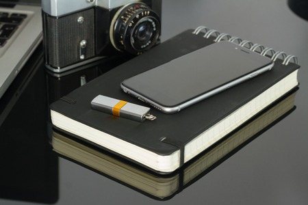 Office black glass desk table with modern phoneの写真素材