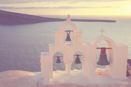 white  church belfry over sea at sunset,  Santorini island, Greece, retro tonedの写真素材
