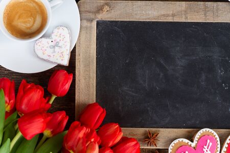 Valentines day coffee with red tulips bouquet, copy space on blackboardの写真素材