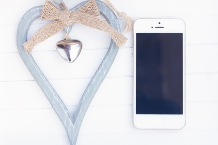 styled desktop with modern phone and gray heartの写真素材