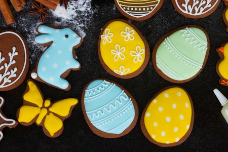 Cooking easter egg cookies on black background, top view