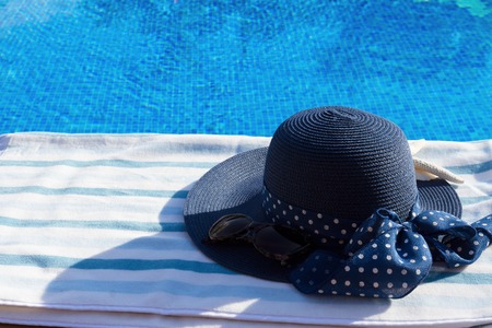 towel and summer hat  near water of poolの写真素材