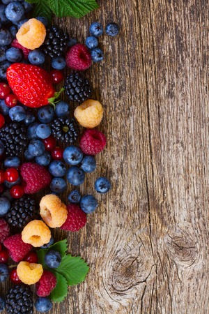 heap of fresh  berries mix on wooden tabletop with copy spaceの写真素材