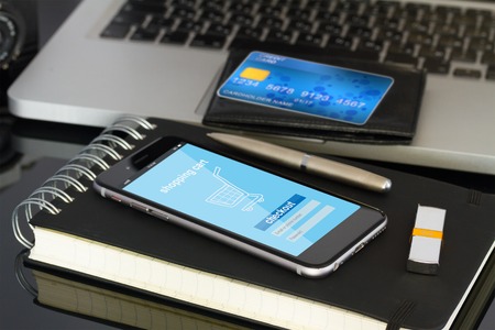 office desktop with internet store page on mobile  phone and plastic cardの写真素材