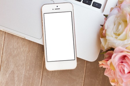 styled desktop with modern phone, pc keyboard and flowers