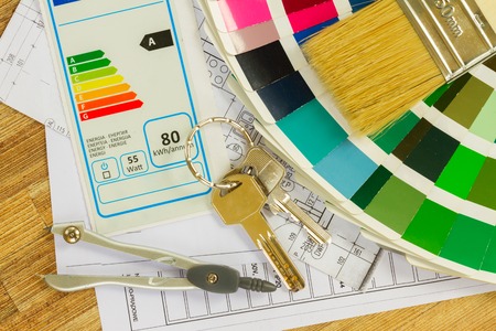 Interior designer's working desktop with  energy rating chart, architectural plan of the house, color palette and  brushesの写真素材