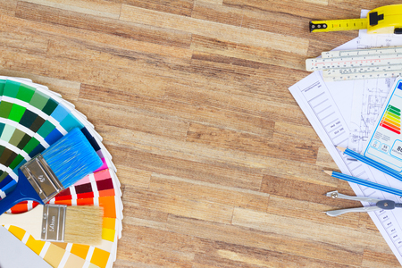 Interior designer's working desktop with  architectural plan of the house, color palette and  brushes, copy space on wooden tableの写真素材