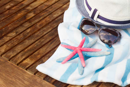 summer beach towel, seashells and hat  on wooden tableの写真素材