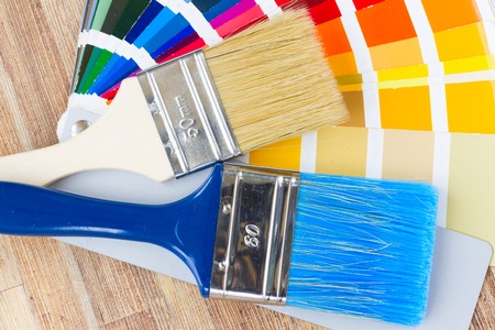 Color palette guide and brushes close up on wooden tableの写真素材