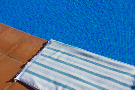 resort background with striped towel  near pool  clear blue  waterの写真素材