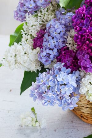 Bunch of fresh lilac flowers in basket close upの写真素材