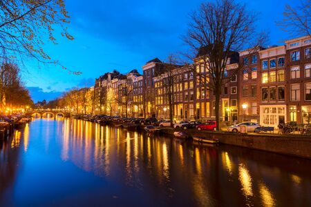 Houses over canal with lights and reflections at night, Amstardam, Netherlandsの写真素材