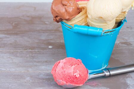 scoops of berry,vanilla and chocolate ice cream with with spoon