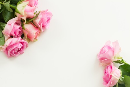 Styled desktop scene with pink fresh rose flowers, copy space on white tableの写真素材