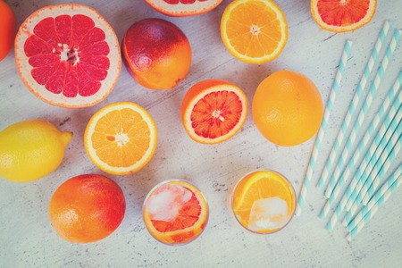Summer refreshing orange, lemon and greipfruit citrus drinks with ice on white table, retro tonedの写真素材