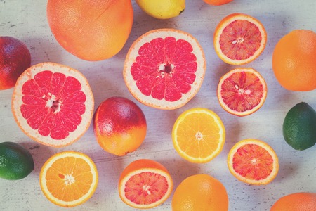 Mix of whole an cut citruses on white table, top view, retro tonedの写真素材